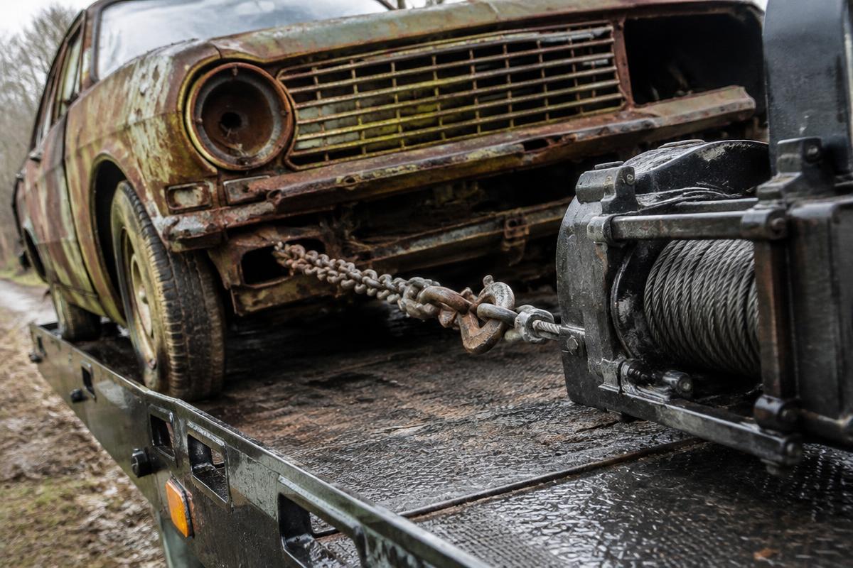 Junk car being winched onto a tow truck